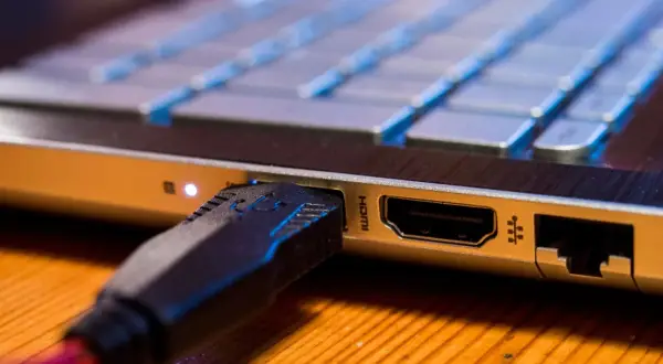 Kabel HDMI podłączony do laptopa, widok z bliska.