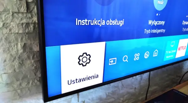 Ekran telewizora Samsung z menu Ustawienia i ikoną koła zębatego.