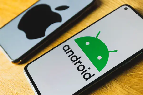 Dwa telefony: jeden z logo Androida, drugi z logo Apple.